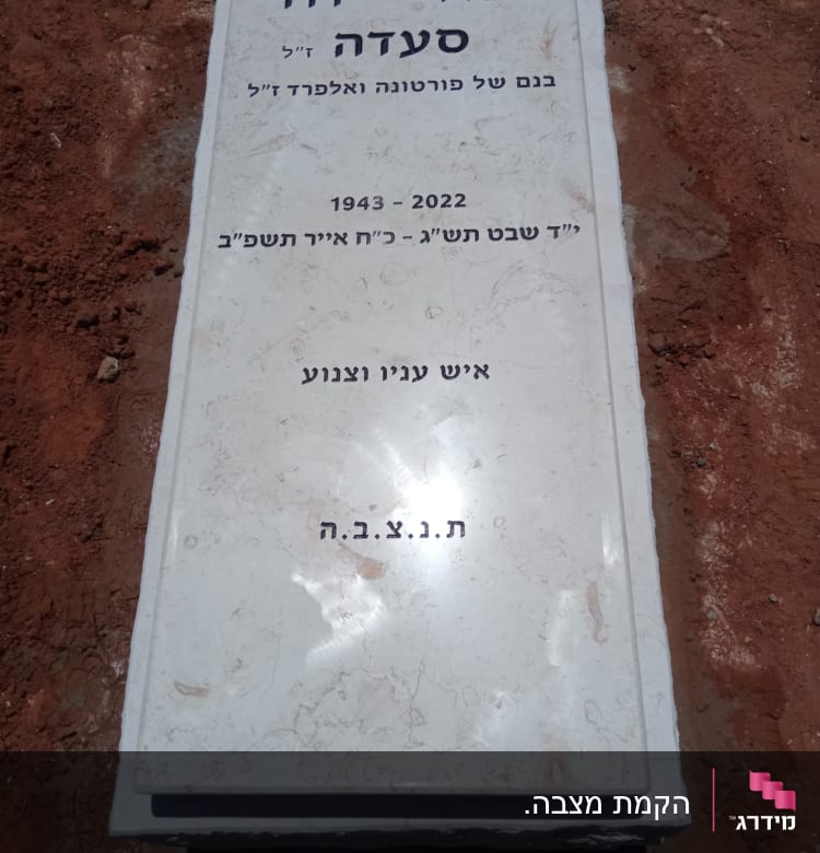 מצבה עם כיתוב בעברית על אדמה